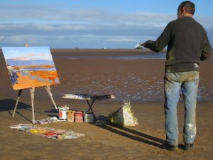 Artist George Rowlett painting plein air on the beach at Humberston