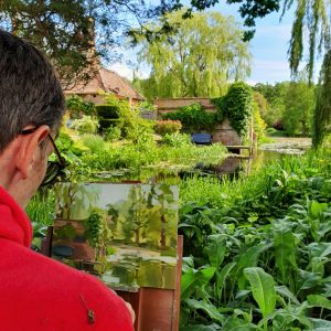 Artist Robert Nelmes painting plein air at Paint Out Elsing Hall Gardens, Norfolk