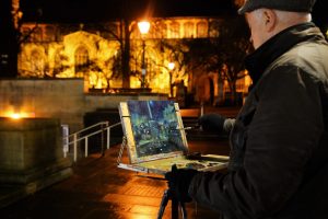 Artist Richard Bond painting from the Market at Paint Out Norwich Winter Nocturne