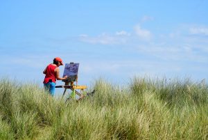 Artist Karen Adams painting on Winterton Beach dunes during Paint Out Norfolk 2020