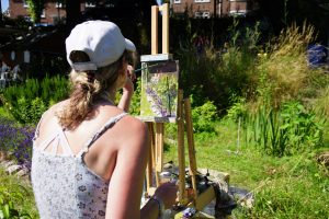 Artist Rachel Wright painting allotments in Norwich during Paint Out Norfolk 2021